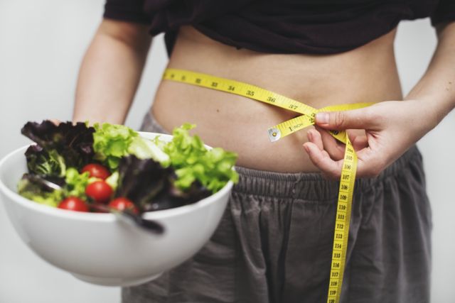 Woman measuring her tummy and weight