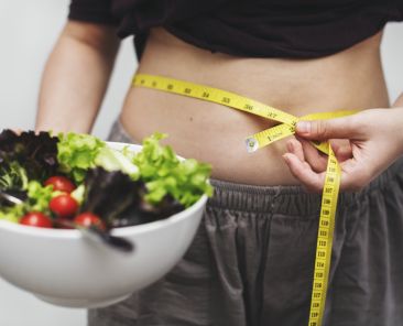 Woman measuring her tummy and weight