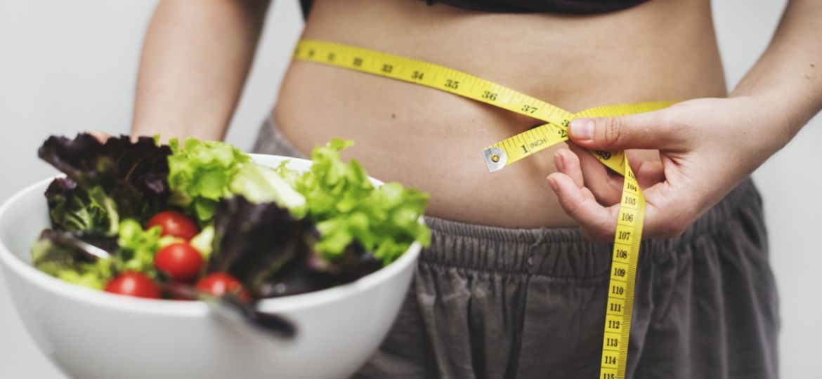 Woman measuring her tummy and weight